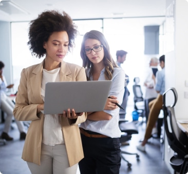 two women look at laptop